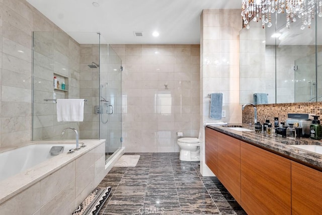 full bath with a garden tub, a sink, tile walls, a shower stall, and double vanity