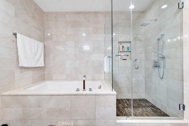 bathroom featuring a stall shower and a bath