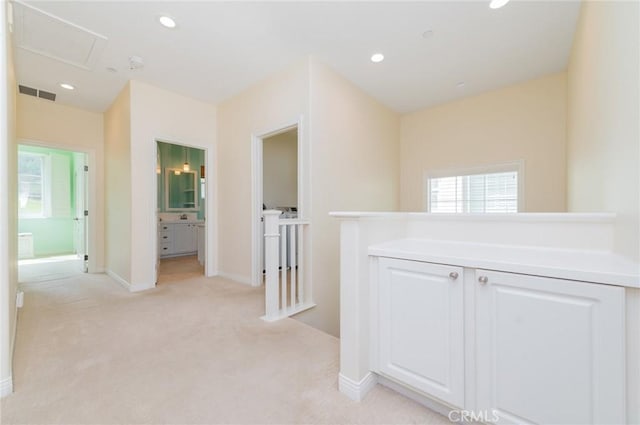 hallway with light carpet, visible vents, baseboards, an upstairs landing, and recessed lighting