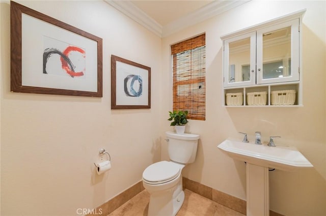 bathroom with baseboards, crown molding, toilet, and tile patterned floors