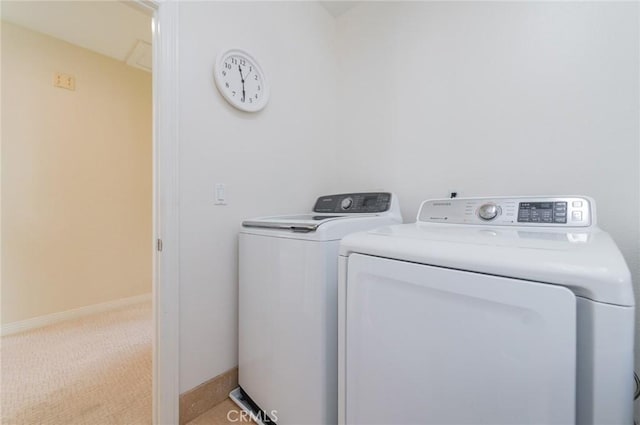 clothes washing area featuring light carpet, laundry area, washing machine and clothes dryer, and baseboards