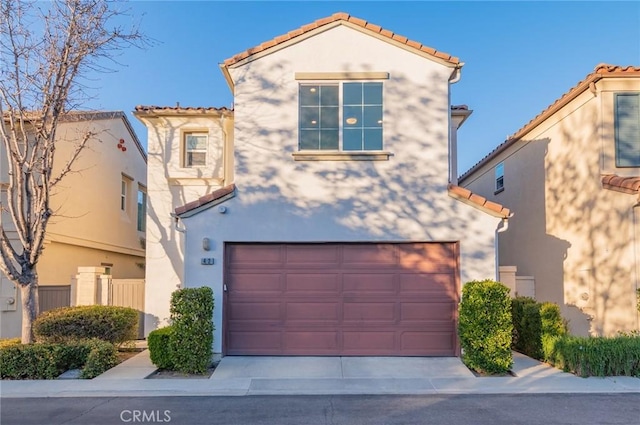 mediterranean / spanish-style house featuring a garage, a tile roof, driveway, and stucco siding