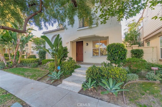 mediterranean / spanish home with fence and stucco siding