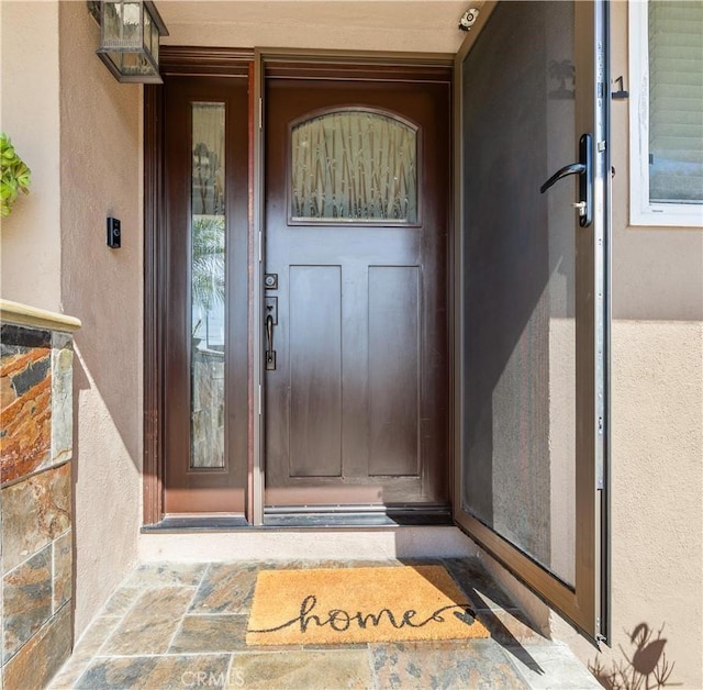 view of exterior entry with stucco siding