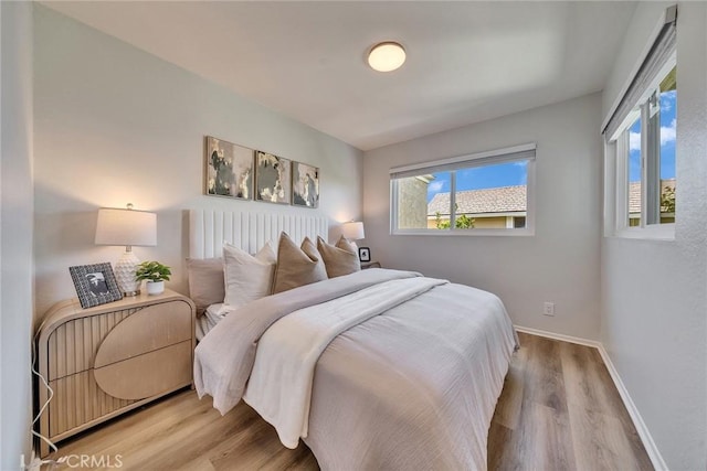 bedroom featuring light wood-style flooring and baseboards