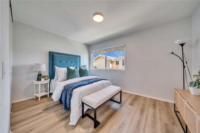 bedroom with baseboards and wood finished floors