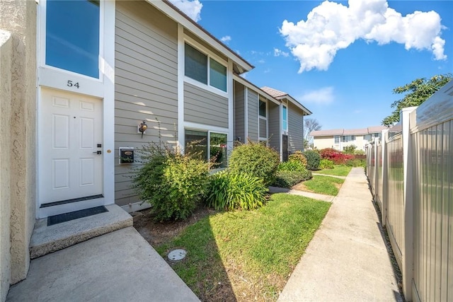 exterior space with a residential view, a lawn, and fence