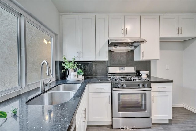 kitchen featuring under cabinet range hood, white cabinets, a sink, and gas stove