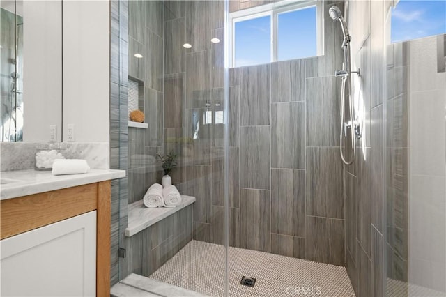 full bath featuring vanity and a tile shower