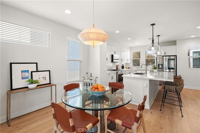 dining room with recessed lighting, baseboards, and light wood-style floors