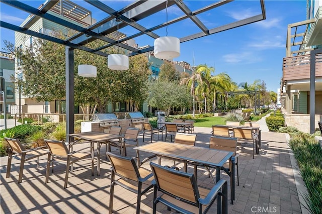 view of patio / terrace featuring exterior kitchen, area for grilling, outdoor dining space, and a pergola