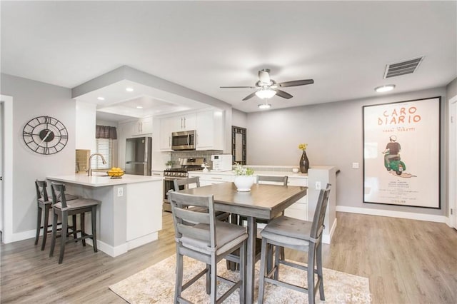 dining space with recessed lighting, baseboards, visible vents, and light wood finished floors