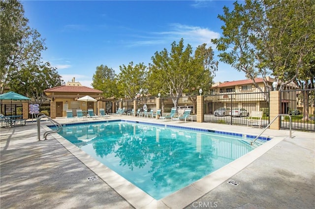 community pool featuring a patio area and fence