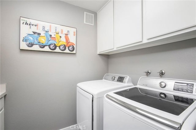 washroom with cabinet space, visible vents, and washing machine and clothes dryer