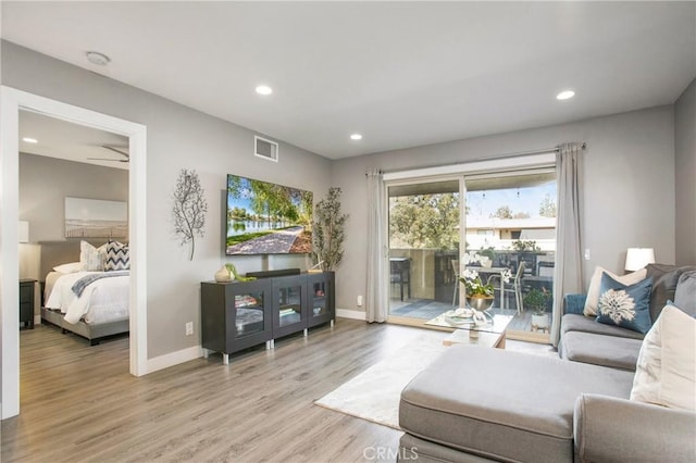 living room featuring light wood-style flooring, visible vents, baseboards, and recessed lighting