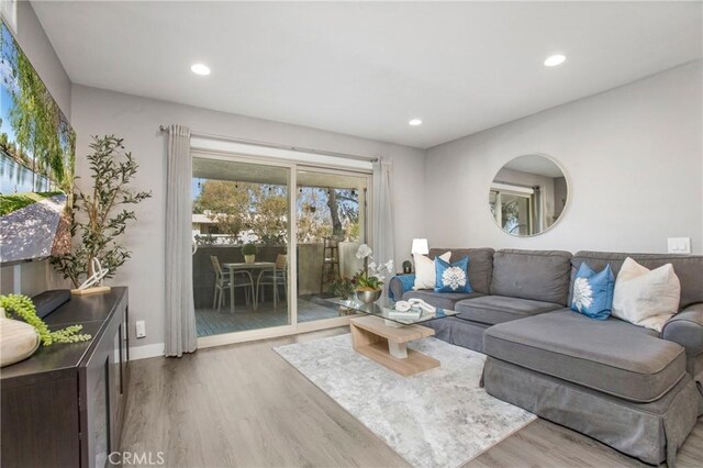 living room with recessed lighting, baseboards, and wood finished floors