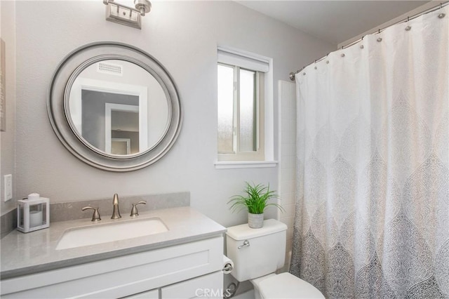 full bath with visible vents, vanity, and toilet