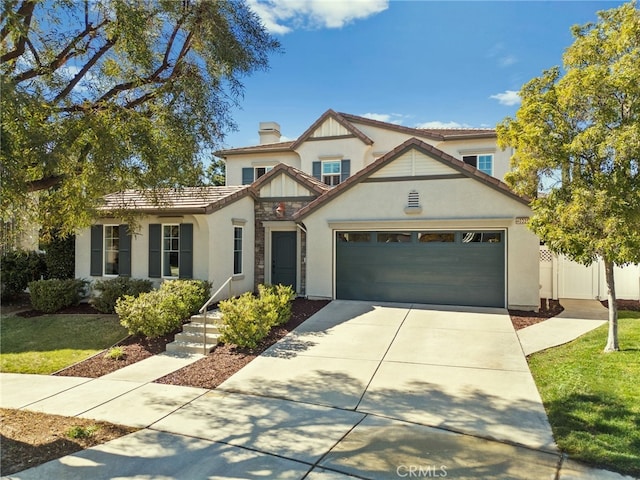 tudor house featuring a garage, driveway, a tiled roof, and stucco siding