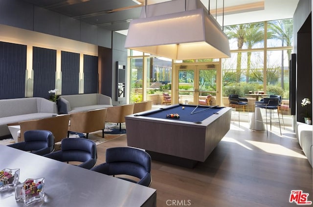 recreation room with a wall of windows, a healthy amount of sunlight, billiards, and wood finished floors