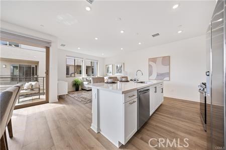 kitchen featuring light wood-style floors, open floor plan, stainless steel dishwasher, and recessed lighting