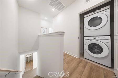 washroom featuring laundry area, visible vents, wood finished floors, stacked washing maching and dryer, and recessed lighting