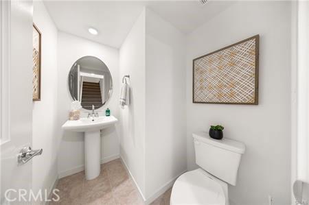 half bath featuring toilet, tile patterned floors, baseboards, and recessed lighting