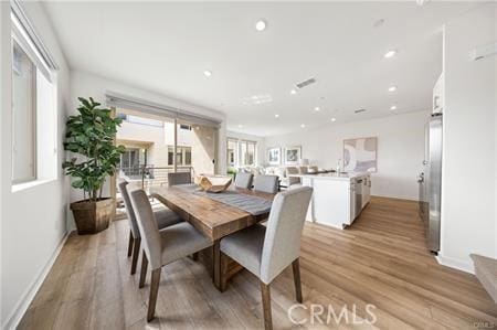 dining area with light wood-type flooring, baseboards, visible vents, and recessed lighting