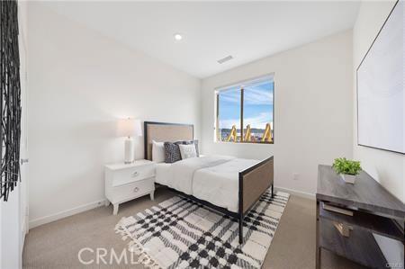 bedroom featuring lofted ceiling, carpet, visible vents, and baseboards