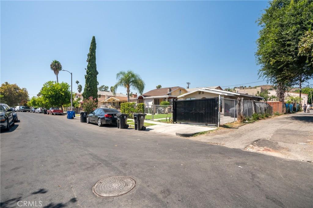 view of road with street lighting, a residential view, and a gate