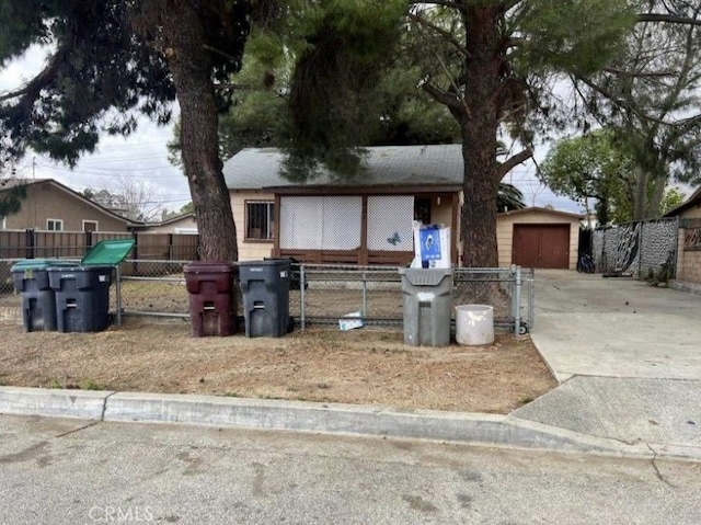 view of front facade featuring a garage, an outdoor structure, and fence