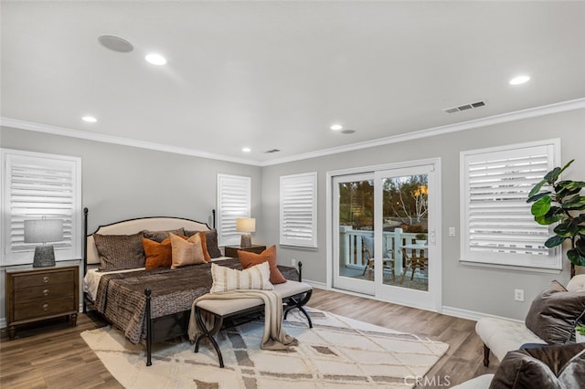 bedroom featuring access to exterior, crown molding, visible vents, and wood finished floors