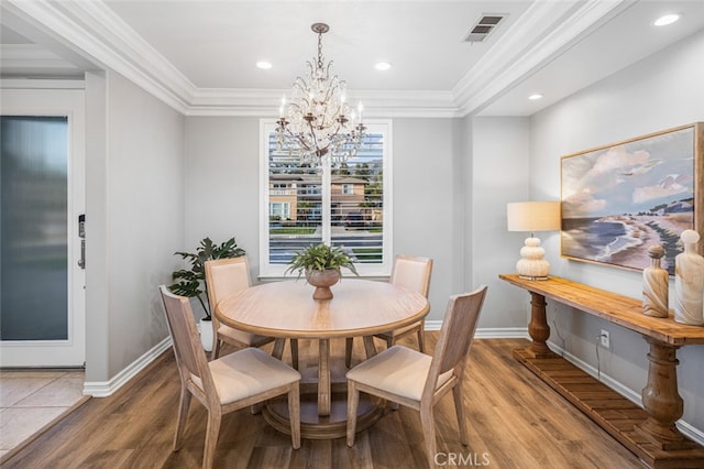 dining area featuring ornamental molding, visible vents, baseboards, and wood finished floors