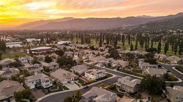 aerial view at dusk featuring a residential view and a mountain view