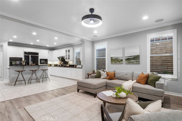 living area featuring light wood-style floors, crown molding, and recessed lighting