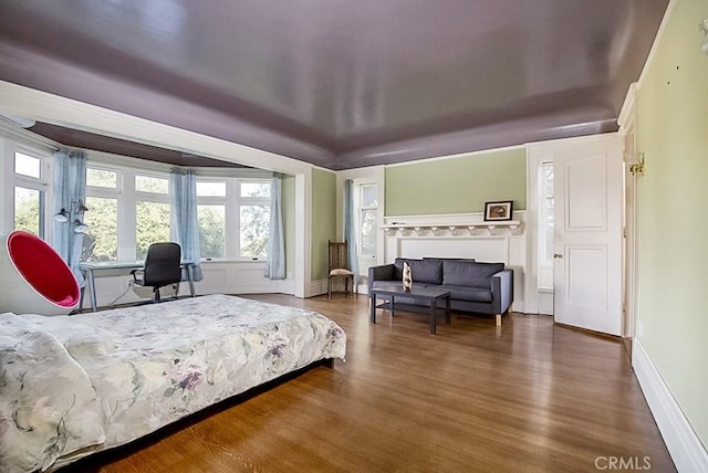 bedroom with wood finished floors and baseboards