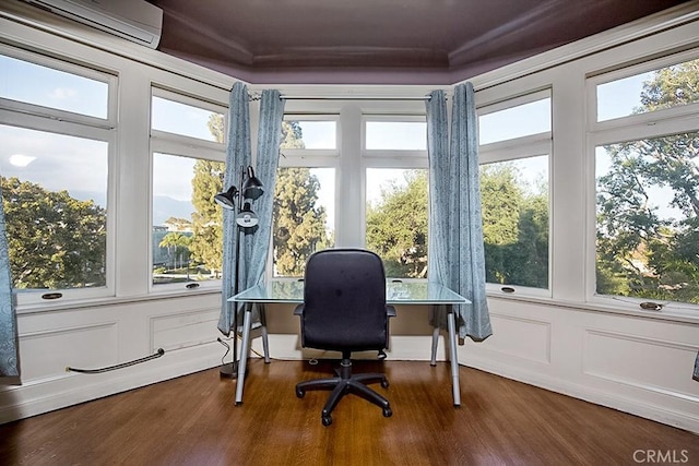 home office featuring dark wood-style floors, a wall mounted AC, and a wealth of natural light