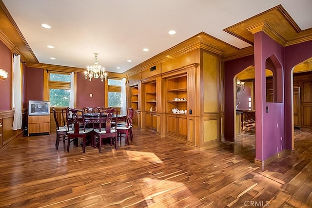 dining room featuring dark wood-style floors, arched walkways, a notable chandelier, and ornamental molding