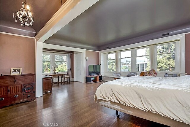 bedroom featuring dark wood-style floors, visible vents, and an inviting chandelier