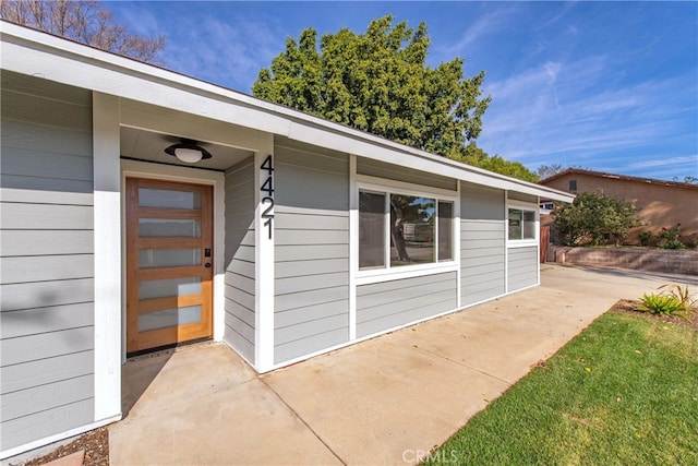 view of exterior entry with a patio area