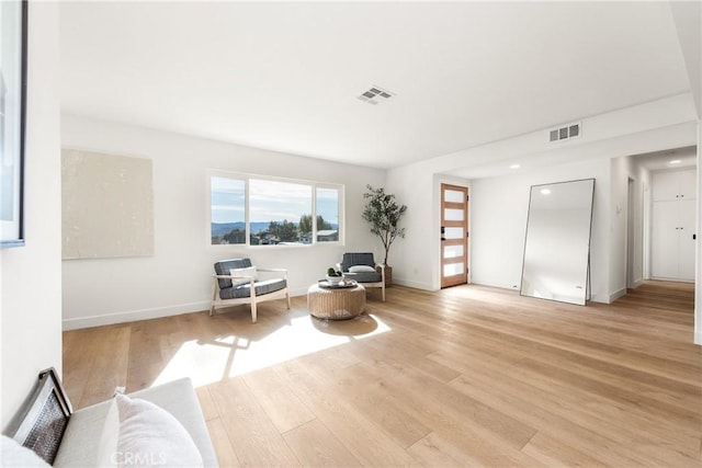 sitting room featuring visible vents, baseboards, and light wood-style flooring