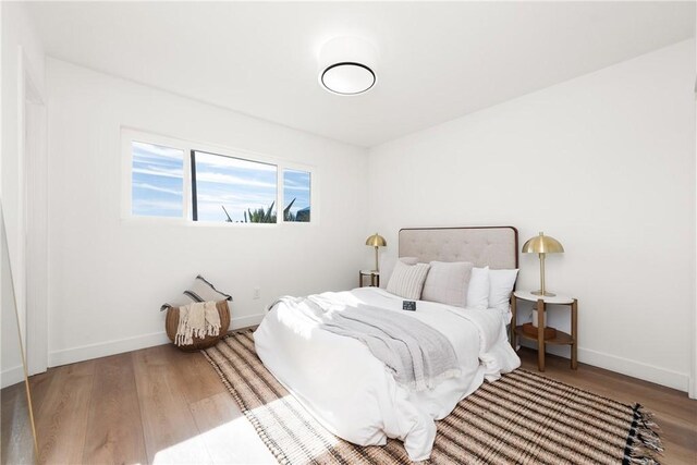 bedroom featuring wood finished floors and baseboards