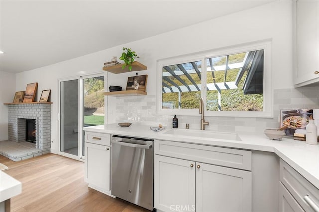 kitchen featuring a sink, a healthy amount of sunlight, light countertops, and stainless steel dishwasher