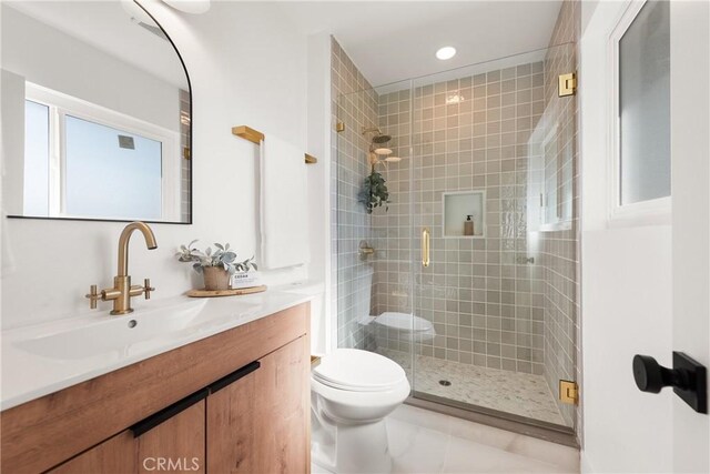 bathroom with recessed lighting, a shower stall, toilet, and vanity