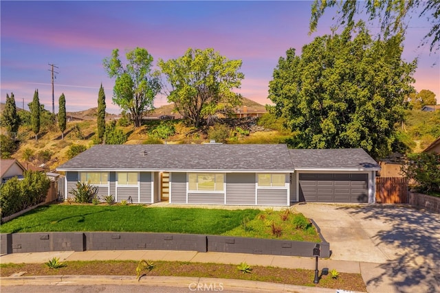 single story home featuring a garage, driveway, a front lawn, and fence