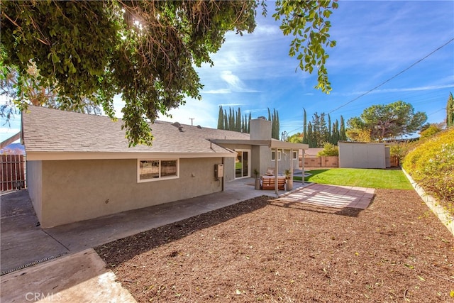 back of property featuring an outbuilding, stucco siding, fence private yard, and a patio