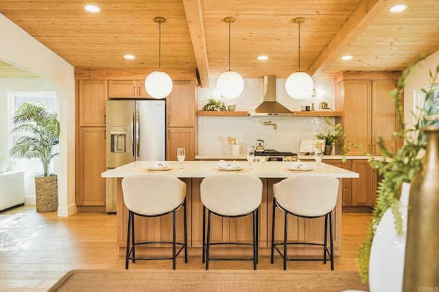 kitchen with wall chimney exhaust hood, open shelves, light countertops, and beamed ceiling