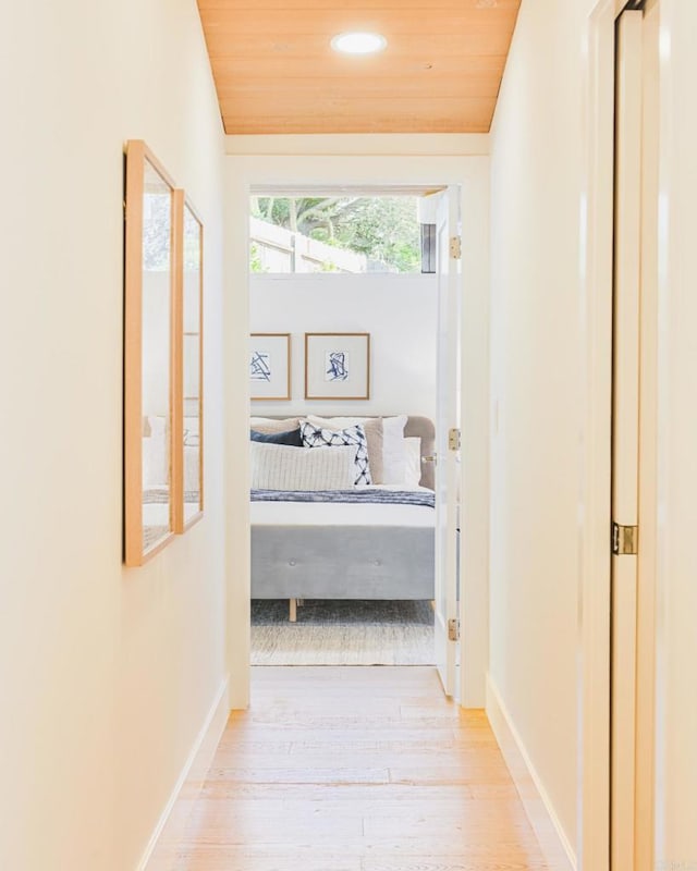 hall featuring lofted ceiling, wood finished floors, wood ceiling, and baseboards