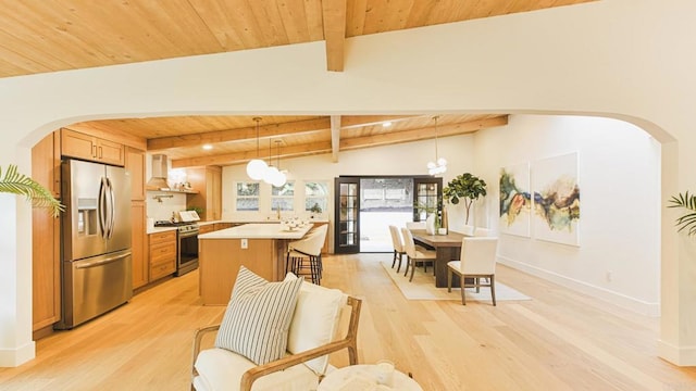 kitchen featuring light wood-style floors, wooden ceiling, stainless steel appliances, light countertops, and wall chimney range hood