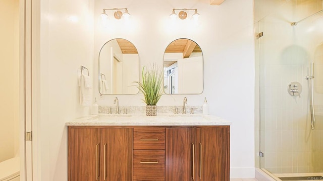 full bath featuring double vanity, a stall shower, and a sink