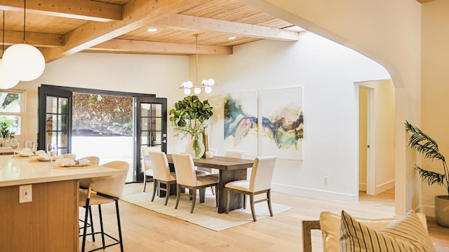 dining space with light wood-type flooring, wood ceiling, arched walkways, and an inviting chandelier